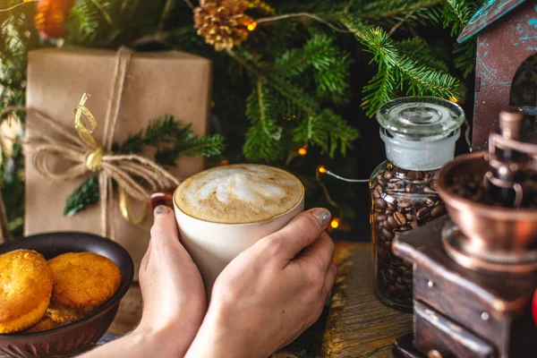 Mug kopi cappuccino pada latar belakang kayu dengan cabang hijau pohon Natal. Hangat dan nyaman dari minuman panas . — Stok Foto