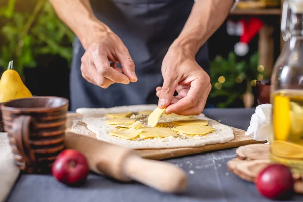 Шеф-повар в черном фартуке готовит рождественское блюдо. Радостная кухня для праздничного новогоднего стола — стоковое фото