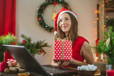 Noel arifesinde hediye olarak kırmızı bir kutu taşıyan güzel bir kadın. Hediye alma duygusallığı