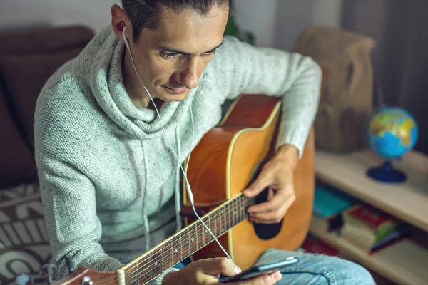 一位年轻的音乐家正在学习弹奏声吉他 一个男人正在近距离弹吉他 — 图库照片