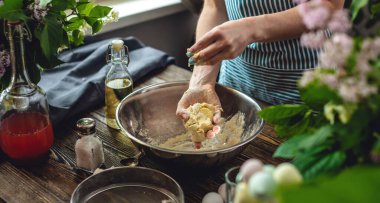 Bir kadın sıcak bir atmosferde taze hamur hazırlıyor. Evde lezzetli hamur yemekleri pişirme kavramı.
