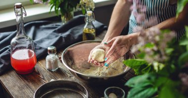Bir kadın sıcak bir atmosferde taze hamur hazırlıyor. Evde lezzetli hamur yemekleri pişirme kavramı.