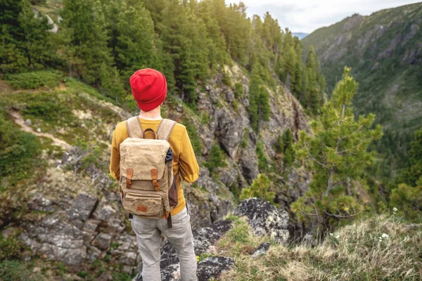 Tourist Traveler Backpack Red Hat Standing Edge Cliff Looking Mountains — Stock Photo, Image