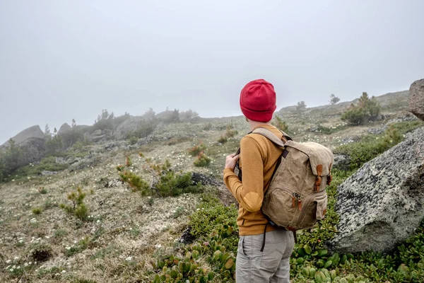 Tourist Traveler Backpack Red Hat Standing Mountains Looking Thick Fog — Stock Photo, Image