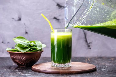 Taze ıspanağın yeşil yapraklarından vejetaryen meyve püresi pişiriyorum. Sağlıklı beslenmek için popüler detoks içeceği.