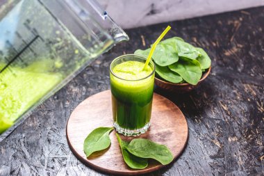 Taze ıspanaktan yapılmış yeşil yapraklardan yapılmış vejetaryen meyve suyu bardağı. Sağlıklı beslenmek için popüler detoks içeceği.