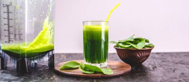 Taze ıspanaktan yapılmış yeşil yapraklardan yapılmış vejetaryen meyve suyu bardağı. Sağlıklı beslenmek için popüler detoks içeceği.