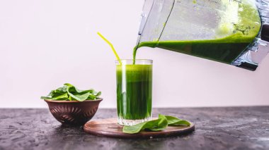 Taze ıspanaktan yapılmış yeşil yapraklardan yapılmış vejetaryen meyve suyu bardağı. Sağlıklı beslenmek için popüler detoks içeceği.