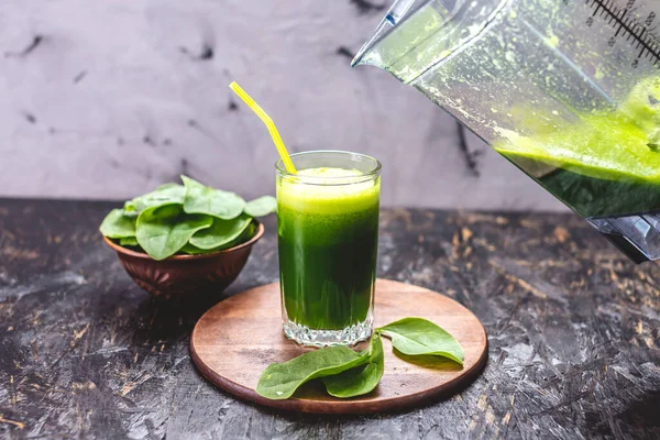 Taze ıspanaktan yapılmış yeşil yapraklardan yapılmış vejetaryen meyve suyu bardağı. Sağlıklı beslenmek için popüler detoks içeceği.