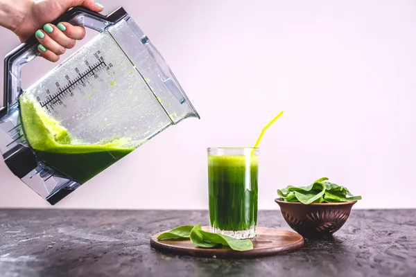 Taze ıspanaktan yapılmış yeşil yapraklardan yapılmış vejetaryen meyve suyu bardağı. Sağlıklı beslenmek için popüler detoks içeceği.