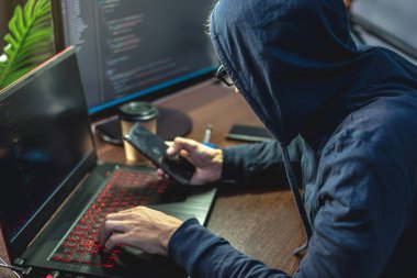 Mahalledeki hacker adam klavyedeki virüs kodunu dizüstü bilgisayar için programlıyor. İnternet dolandırıcılığı ve kişisel veri hackleme kavramı