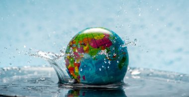 Dünya gezegeni bir küre şeklinde şeffaf sularda ve su sıçramalarıyla. Çevre dostu davranış ve suyu temiz tutma kavramı