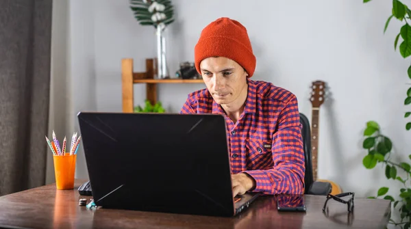 Nowoczesny Młodzieniec Czerwonej Koszuli Kapeluszu Pracuje Nad Laptopem Pojęcie Komunikacji — Zdjęcie stockowe