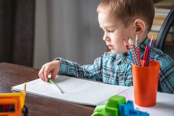 かわいい子供はテーブルのアルバムの紙に鉛筆で描いています 就学前教育の概念と創造性の発達 — ストック写真