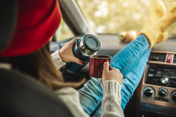 모직으로 양말을 차안에 여자가 보온병에서 커피를 여행의 자유라는 — 스톡 사진