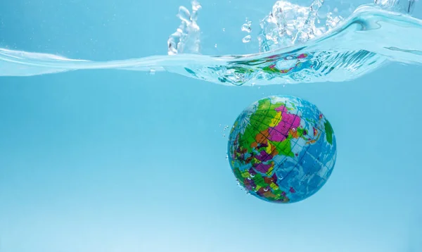 Planeta Ziemia Postaci Globu Zanurza Się Czystej Wodzie Tworząc Plamy — Zdjęcie stockowe