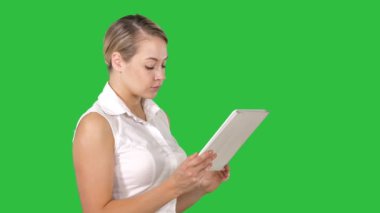Güzel kadın ayakta ve tablet Chroma anahtar yeşil ekran kullanma.