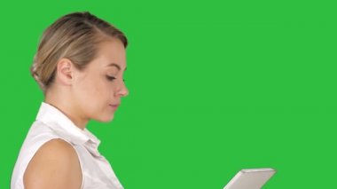 Yan görünümü kapatın. Tek kız yürüyüş ve medya içeriği bir tablet Chroma anahtar yeşil ekranda bir satır izliyor. 4 k çözünürlüklü profesyonel vurulmuş. 005. sen-ebilmek kullanma bu bir örneğin, ticari