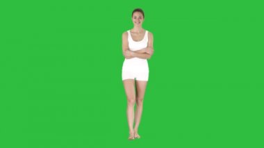 Elbise yalınayak ve yaygın bir ekranda yeşil, Chroma Key gülümseyen genç kadın beyaz yürüyüş spor.