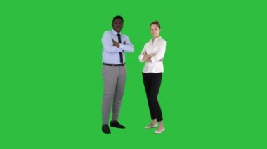 Uluslararası iş adamları Chroma anahtar yeşil ekranda katlanmış silah ile ayakta.