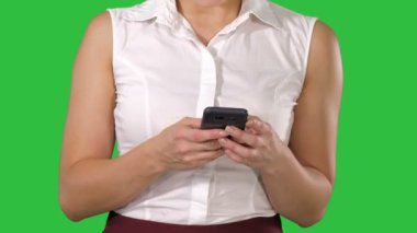 Cep telefon yeşil ekranda Chroma Key holding kadın eller.