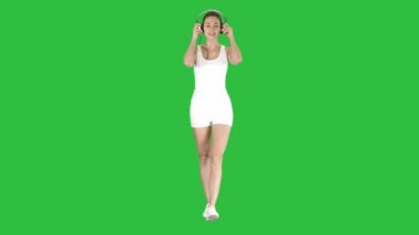 Sporcumuz kulaklık Chroma anahtar yeşil ekranda müzik dinleme.