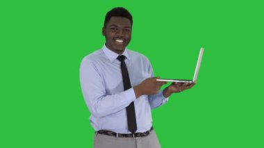 Orta atış. Kamera Afrika delikanlı ile laptop onun elinde bir yeşil ekranda Chroma Key konuşuyordum. 4 k çözünürlüklü profesyonel vurulmuş. 012. sen-ebilmek kullanma o bir örneğin, ticari video, tıbbi