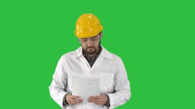 Site mühendis cheching kağıtları ve çevresindeki Chroma anahtar yeşil ekranda bir şey.