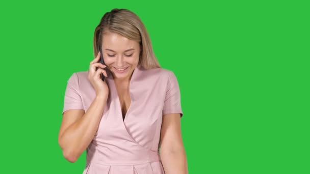 Jonge vrouw praten met iemand op haar mobiele telefoon in een groen scherm, Chromakey. — Stockvideo