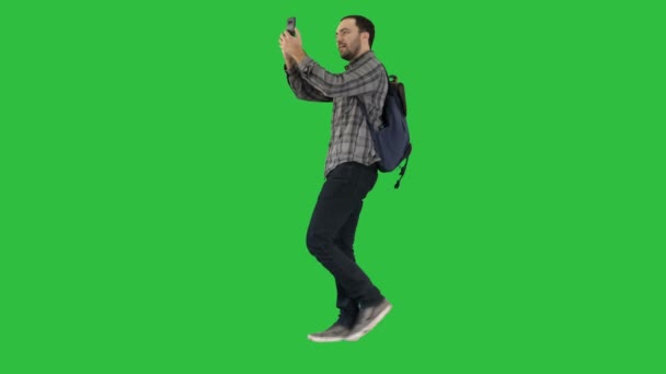 Ung attraktiv student backpacker turist tar selfie foto med mobiltelefon på en grön skärm, Chroma Key. — Stockvideo