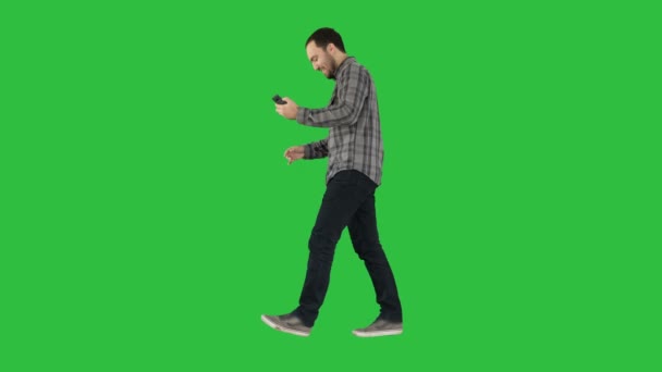 Attraktiver Mann mit kurzen dunklen Haaren, der nach dem Selfie auf einem grünen Bildschirm Fotos checkt, Chroma-Schlüssel. — Stockvideo