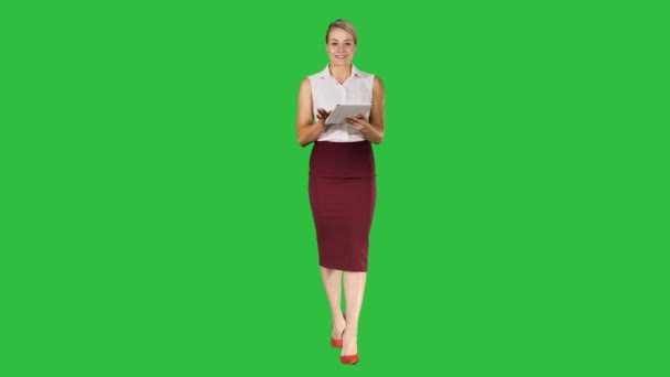 Χαμογελώντας επιχειρηματίας χρησιμοποιώντας ηλεκτρονική καρτέλα swiping και κοιτάζοντας την κάμερα ενώ το περπάτημα σε μια πράσινη οθόνη, Chroma Key. — Αρχείο Βίντεο