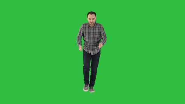 Молодой человек в повседневной одежде ходит и танцует на зеленом экране, Chroma Key . — стоковое видео