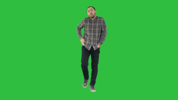 Νεαρός άνδρας περπατώντας με τα χέρια του τσέπες και σφυρίχτρες σε μια πράσινη οθόνη, Chroma Key. — Αρχείο Βίντεο