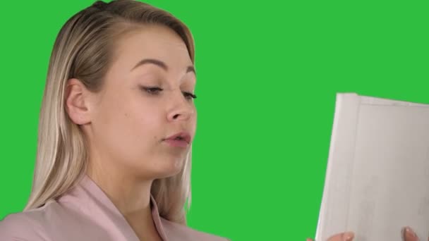 Fröhliche positive Mädchen macht Videoanruf auf einem grünen Bildschirm, Chroma-Taste. — Stockvideo