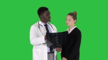 Genç kadın ziyaret radyolog x-ray sınav üstünde a yeşil perde, Chroma Key beyninin için.