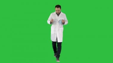 Maske ve kap yeşil ekranda Chroma Key giyen yürüyen yakışıklı Doktor.