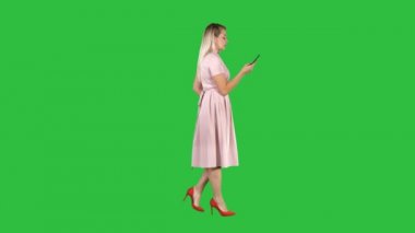 Bir yeşil ekran, Chroma Key telefonda konuşurken pembe elbiseli kadın.
