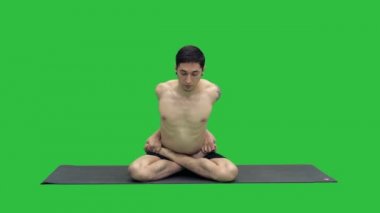 Lotus pozisyonu Chroma anahtar yeşil ekranda pratik yoga genç adam.