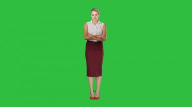 Chroma anahtar yeşil ekran katlanmış silah tutmak kamera seyir resmi elbise giyen genç kadın.