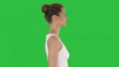 Chroma anahtar yeşil ekran yürüyen sıradan genç kadın.
