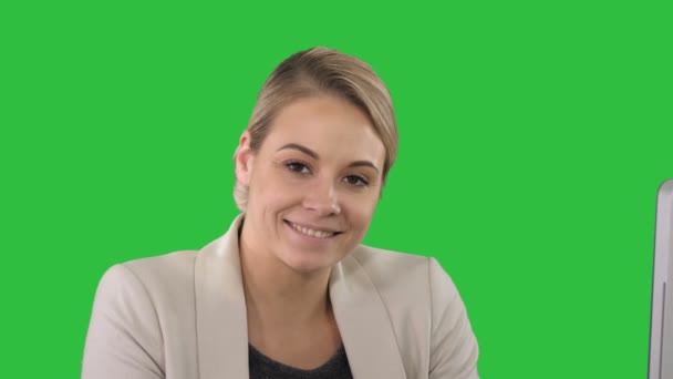 Lächelnde junge Frau, die auf einem grünen Bildschirm in die Kamera blickt, Chroma-Schlüssel. — Stockvideo