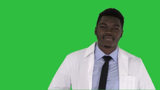 非洲男性医生用手站在他的口袋在绿色屏幕上, 色度键. — 图库视频影像