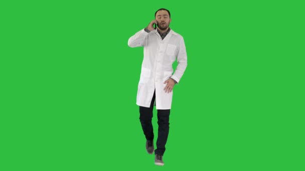 Médico masculino caminando y hablando por teléfono en una pantalla verde, Chroma Key . — Vídeos de Stock