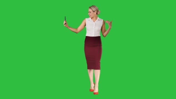 Wandelen vrouw maken van een video-oproep met behulp van slimme telefoon op een groen scherm, Chromakey. — Stockvideo