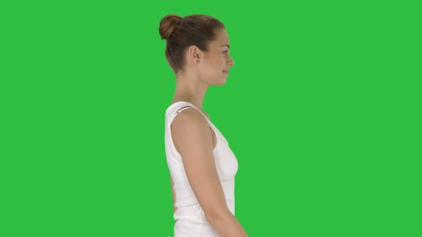 Mujer joven casual en la parte superior blanca caminando en una pantalla verde, Chroma Key . — Vídeos de Stock