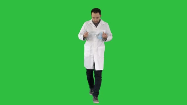 Walking handsome doctor wearing mask and cap on a Green Screen, Chroma Key. — Stock Video