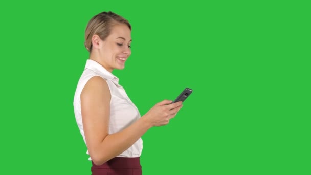 Halva längden porträtt av ung affärskvinna tittar på hennes telefon på en grön skärm, Chroma Key. — Stockvideo