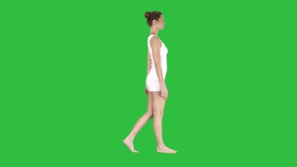 Één vrouwtje blootsvoets lopen in witte kleren op een groen scherm, Chromakey. — Stockvideo