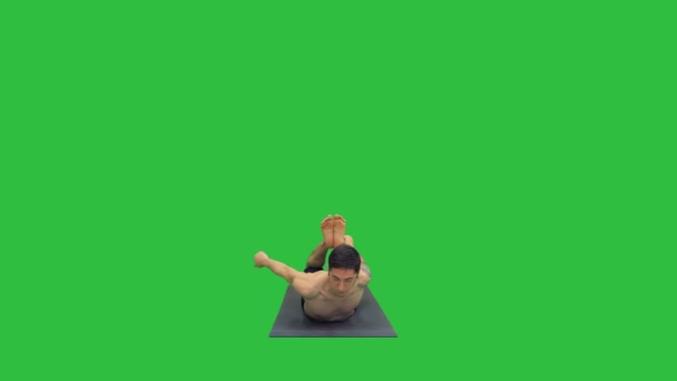 Hemdloser athletischer Mann demonstriert eine Yoga-Bogen-Pose auf Matte auf einem grünen Bildschirm, Chroma-Schlüssel. — Stockvideo